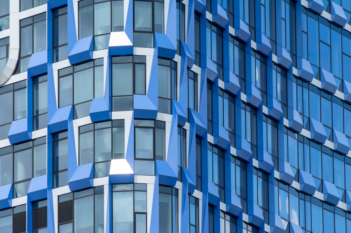 Geometrische blauwe gevel in Amsterdam, gebruikt in een fictief architectuurwebsiteconcept